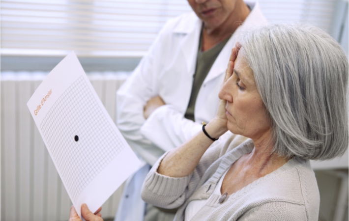 A female patient is using an Amsler grid at the eye care clinic with the help of an optometrist in order to screen for Age-related Macular Degeneration